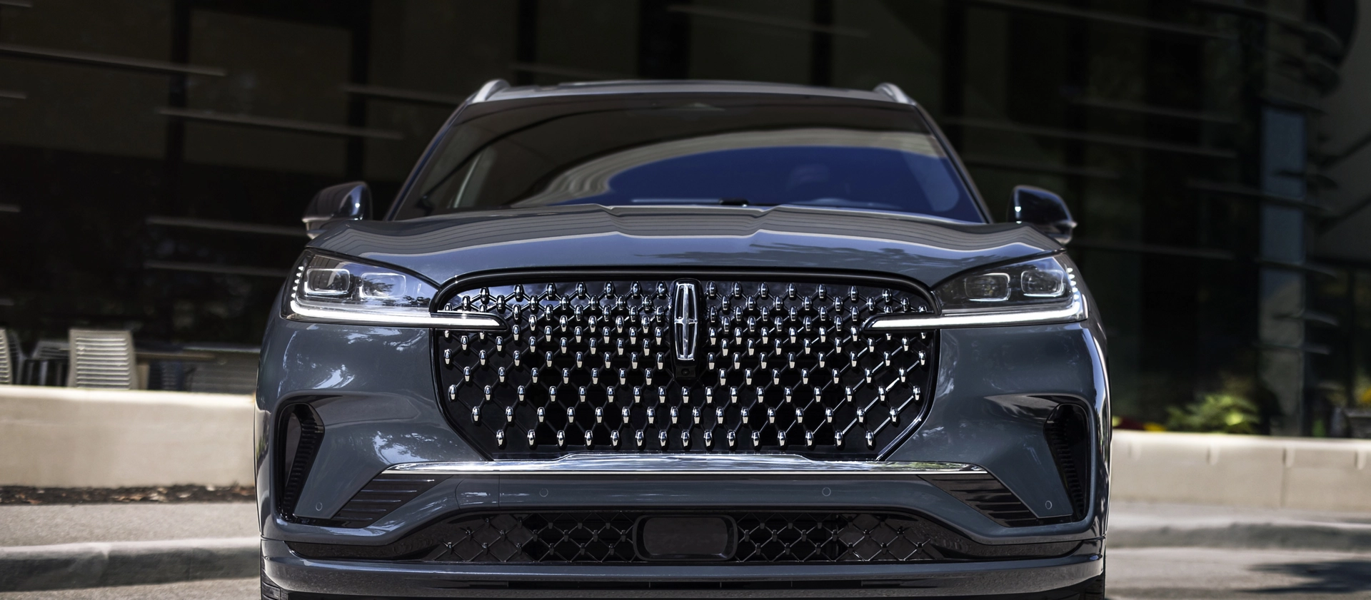 The dazzling grille of a 2025 Lincoln Black Label Aviator® SUV sparkles in the sunlight