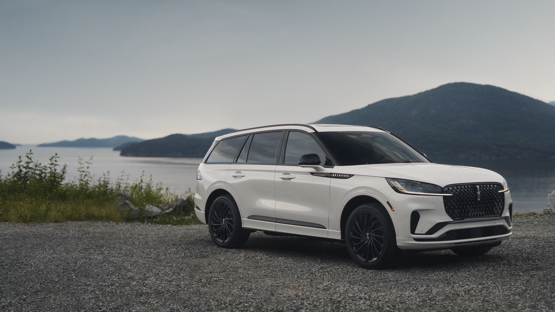 A 2025 Lincoln Aviator® SUV is parked by a scenic lakeside overlook.
