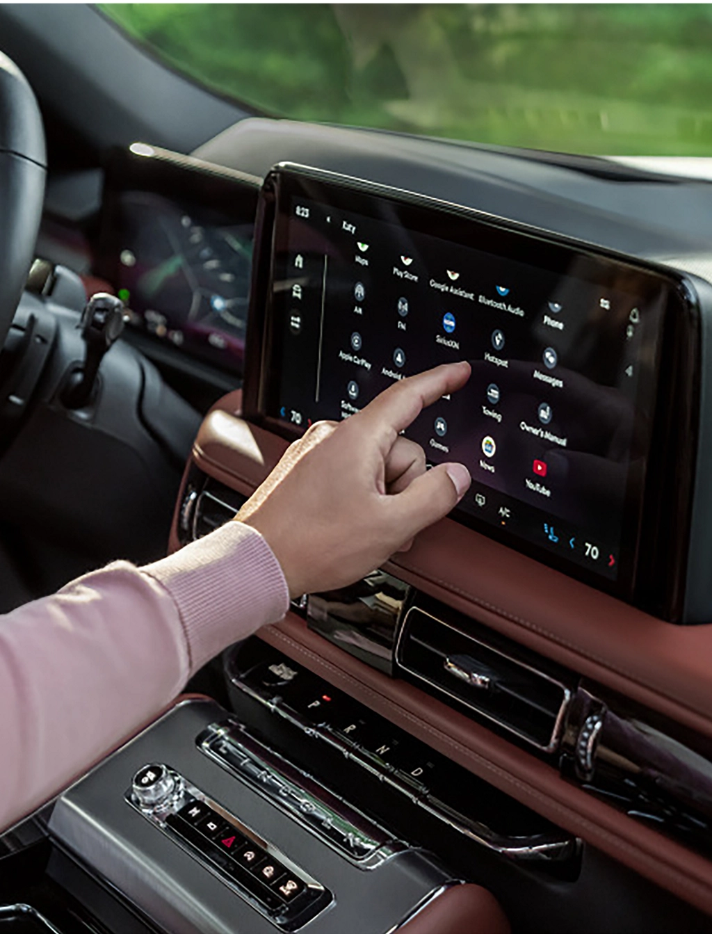 A man using the center touchscreen on his Lincoln Aviator.