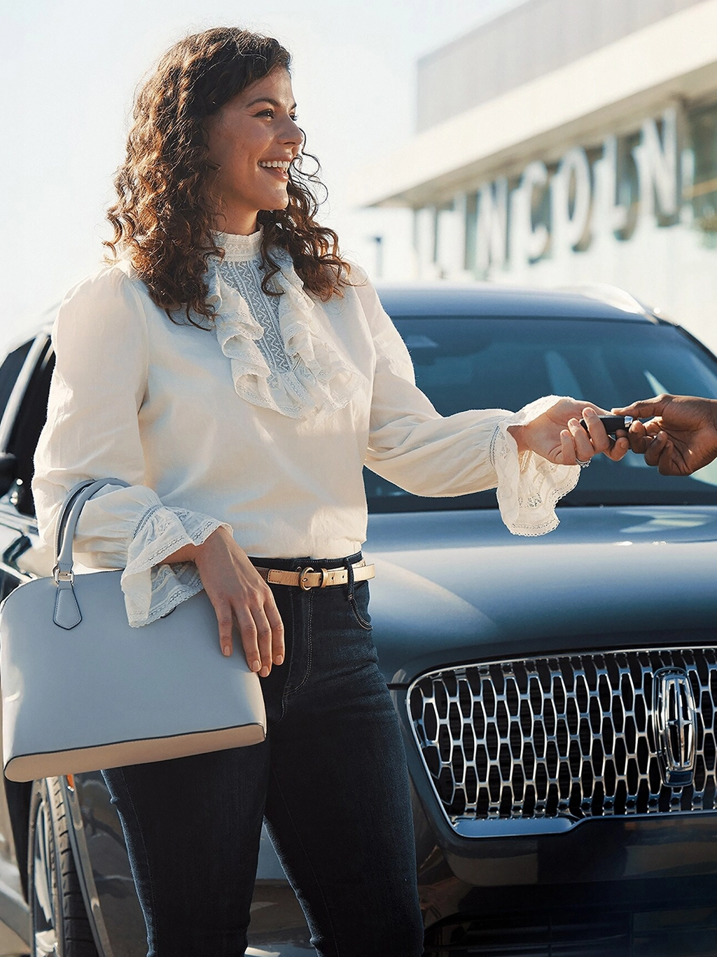 A woman picking up her Lincoln vehicle.