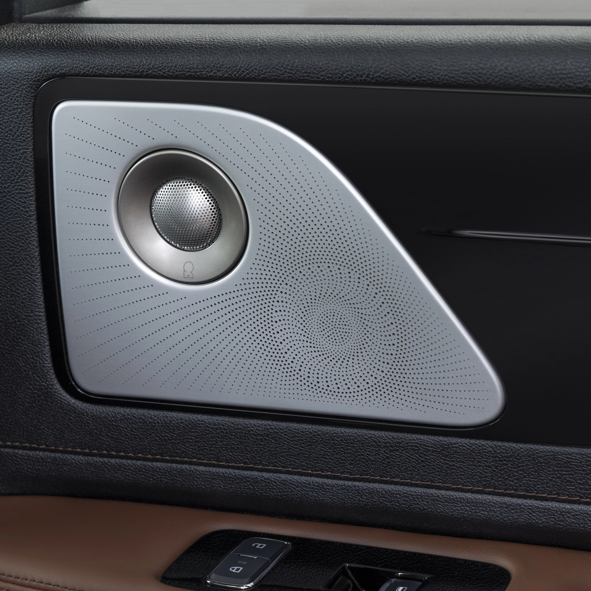 A Revel® speaker is shown on the interior door pane of a 2026 Lincoln Aviator® SUV