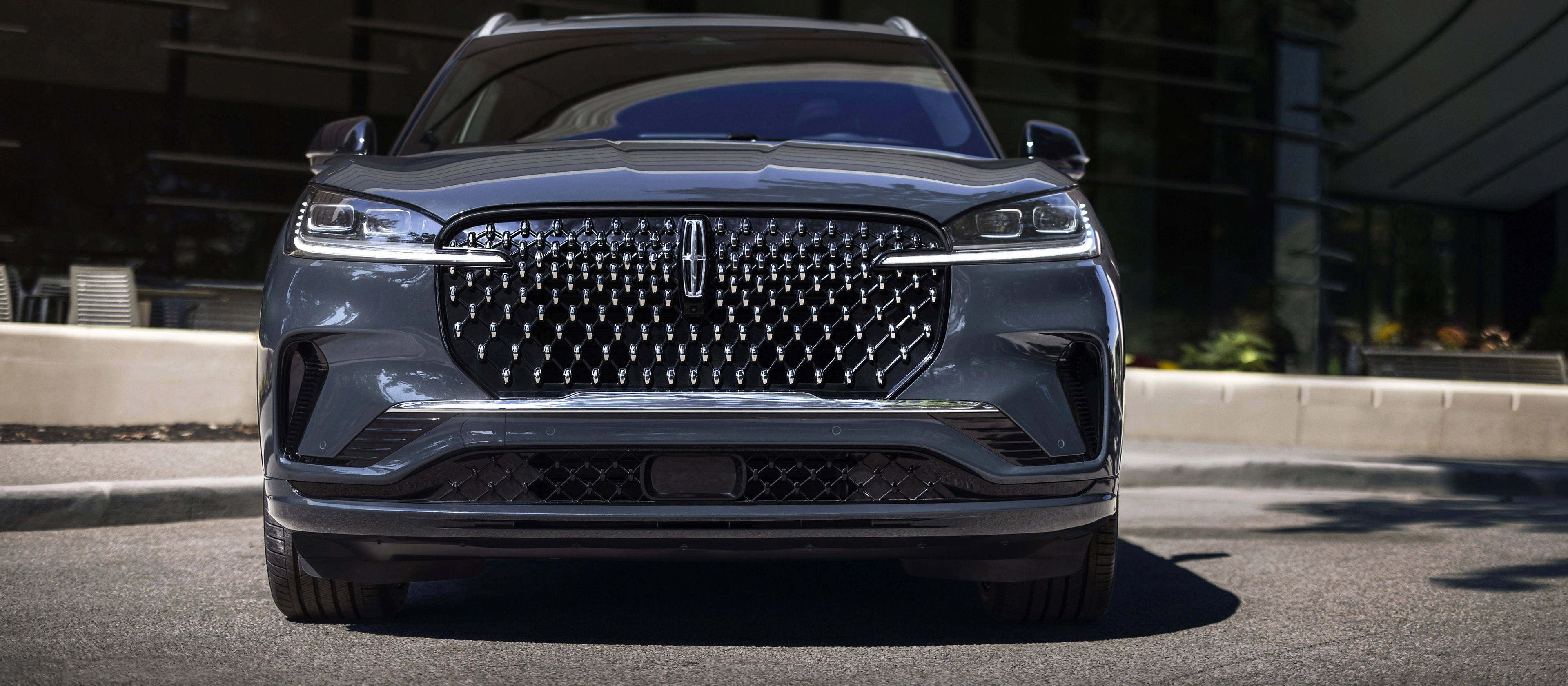 The dazzling grille of a 2026 Lincoln Black Label Aviator® SUV sparkles in the sunlight