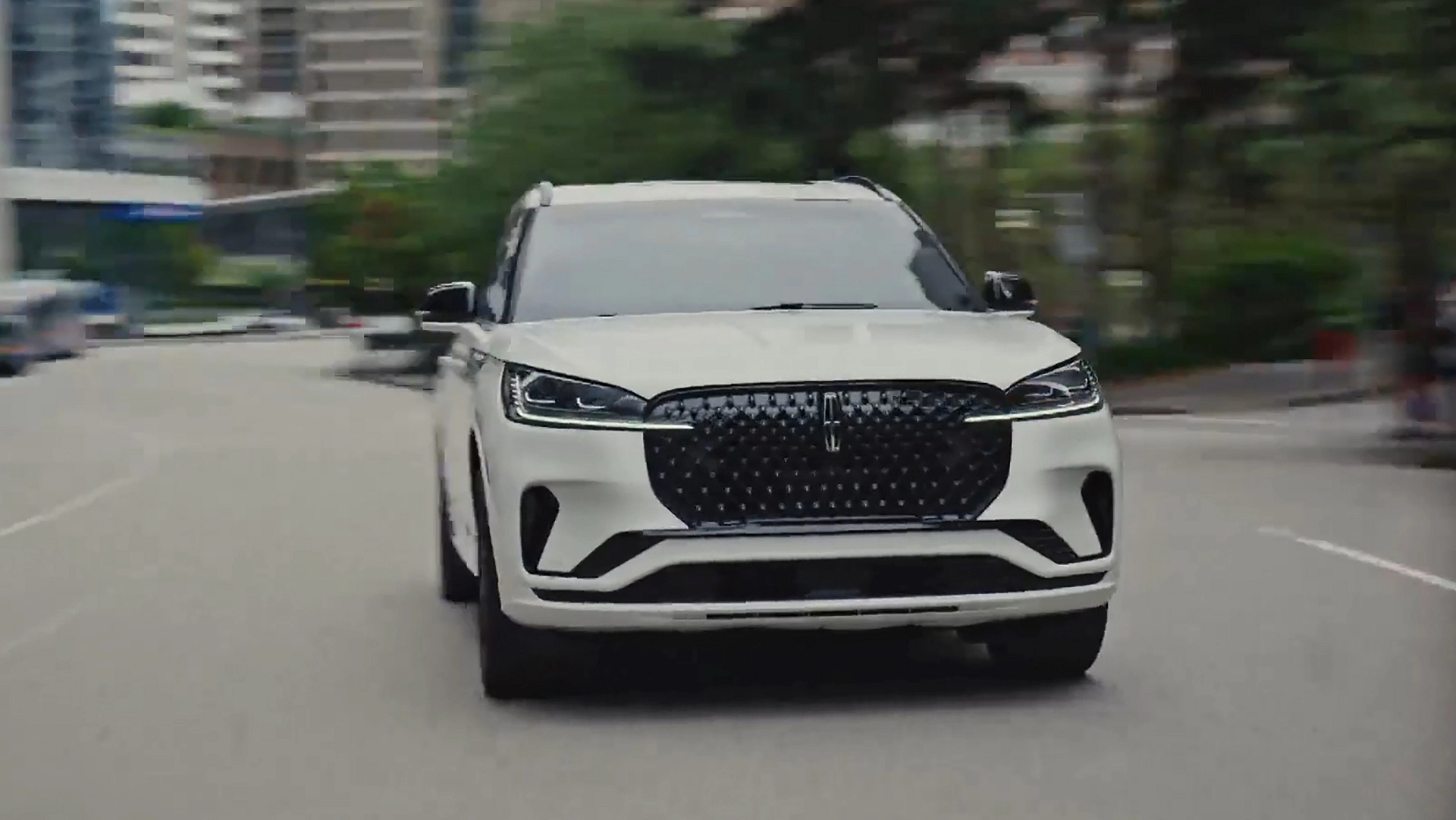 A 2026 Lincoln Aviator® SUV is being driven on a highway near a city