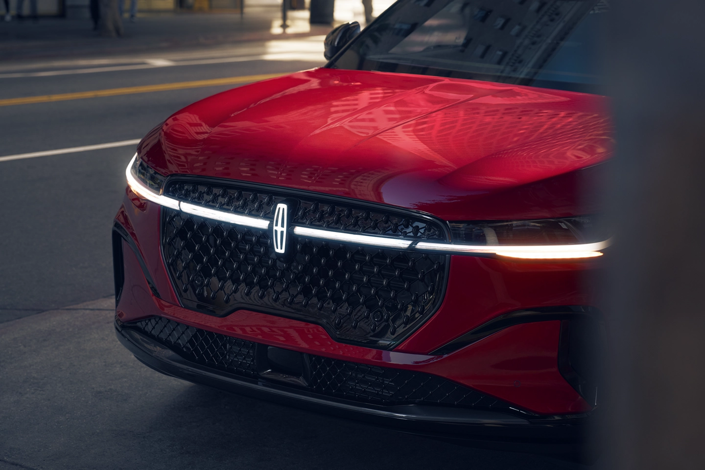 The front angle of a red colored Lincoln vehicle.
