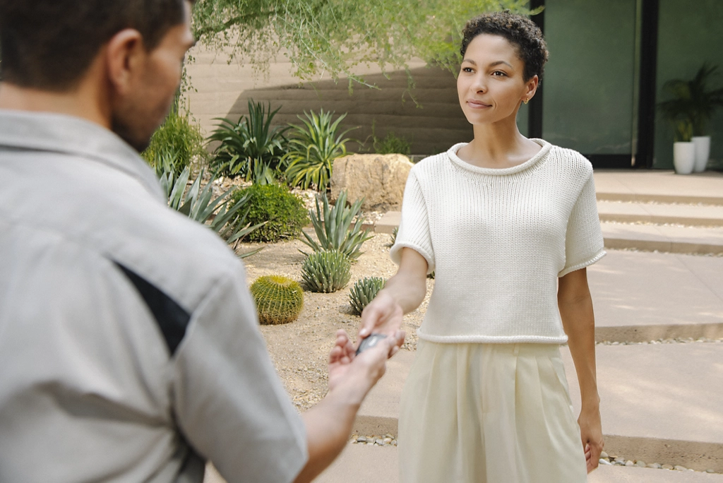 A man and a woman exchanging a cell phone.