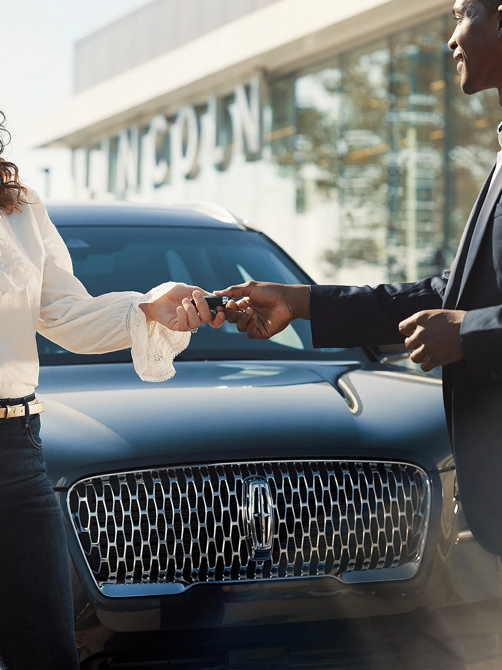 A woman picking up her Lincoln vehicle.