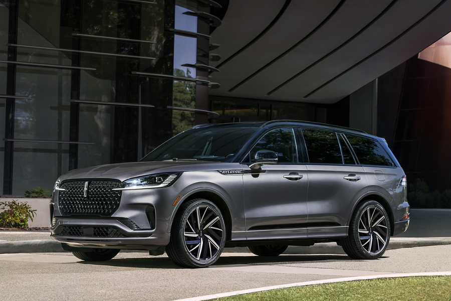 Una SUV Lincoln Black Label Aviator® 2025 de color exterior gris ceniza estacionada frente a un edificio