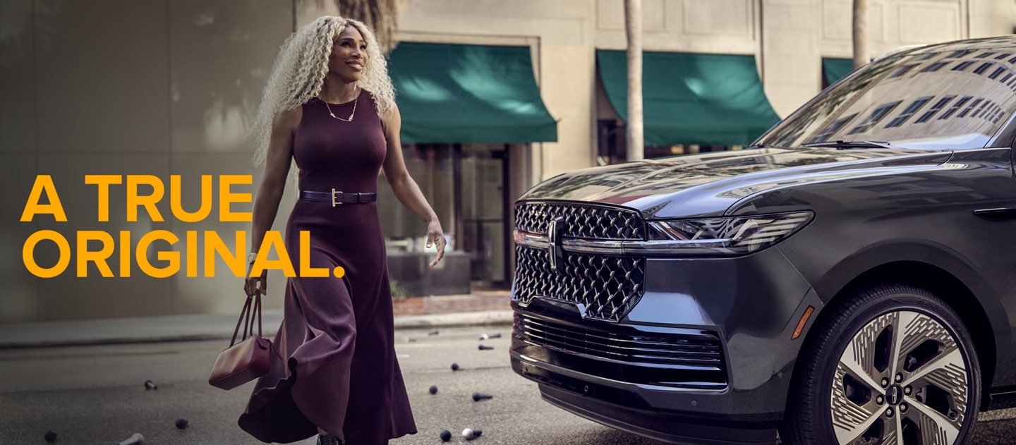 Serena Williams apoyada en un vehículo Lincoln.