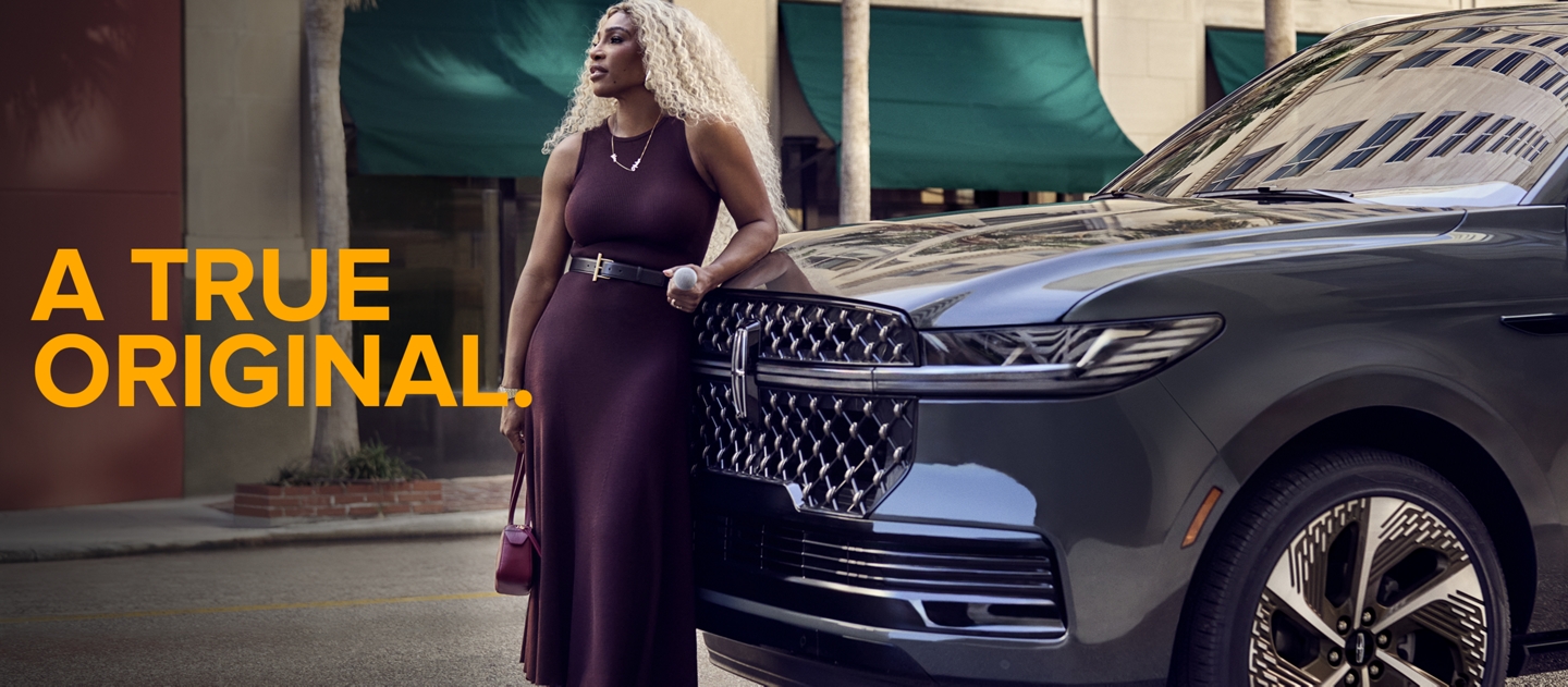 Serena Williams apoyada en un vehículo Lincoln.